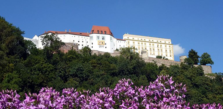 Foto von der Veste Oberhaus mit Blumen im Vordergrund.